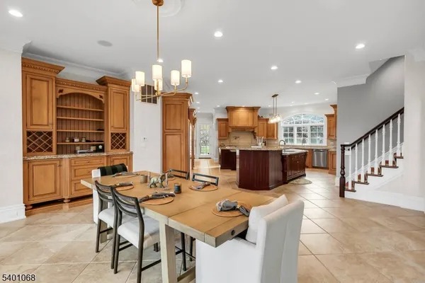 a kitchen with stainless steel appliances kitchen island granite countertop a refrigerator a stove a kitchen island a dining table and chairs