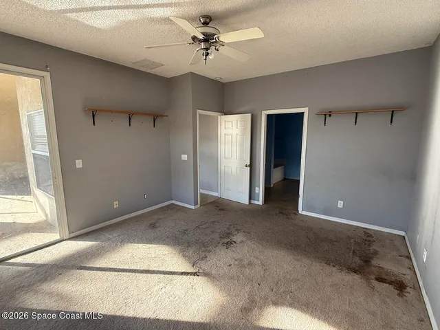 a view of a big room with a ceiling fan and a bathroom