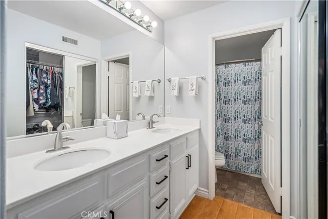 a bathroom with a double vanity sink mirror and shower