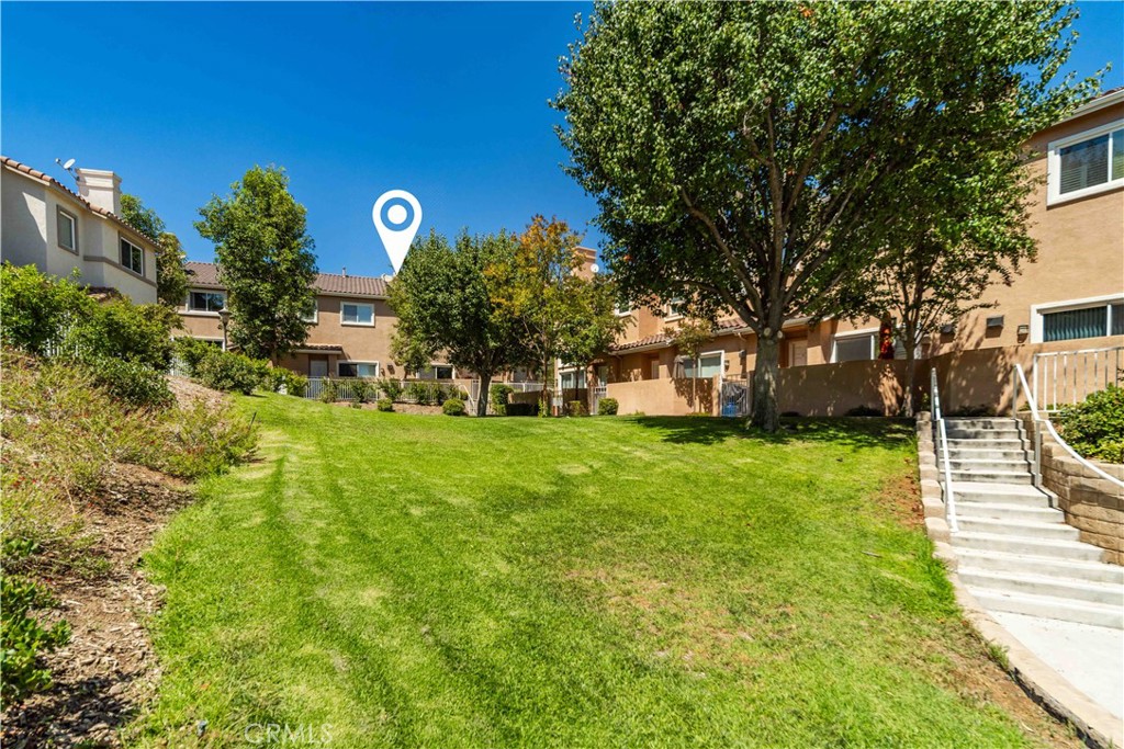 25710 Wagner Way, Unit C Stevenson Ranch, CA 91381 - Photo 3 of 37 a front view of a house with a yard