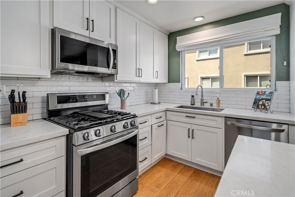 25710 Wagner Way, Unit C Stevenson Ranch, CA 91381 - Photo 5 of 37 a kitchen with a stove a sink and a microwave