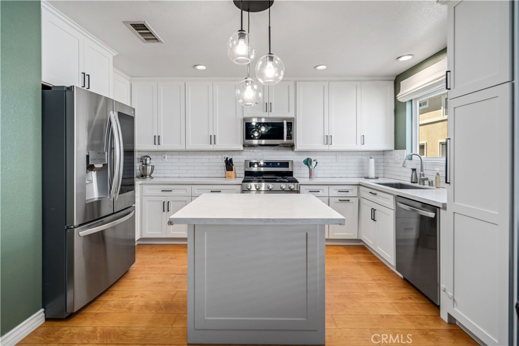 25710 Wagner Way, Unit C Stevenson Ranch, CA 91381 - Photo 6 of 37 a kitchen with stainless steel appliances granite countertop a refrigerator a stove a sink and a microwave