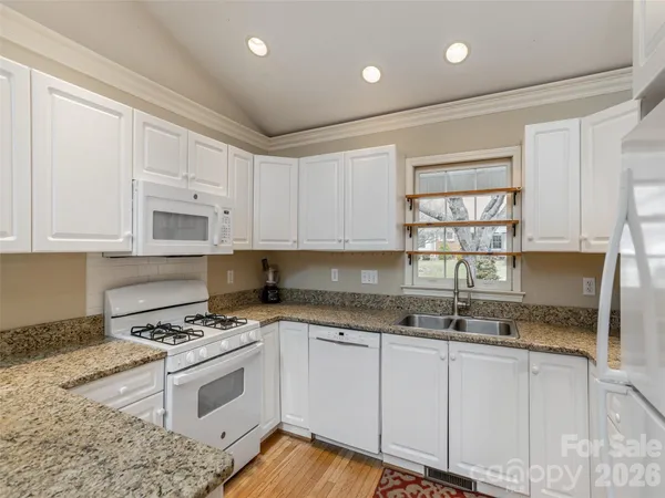 a kitchen with granite countertop a stove a sink and a cabinets