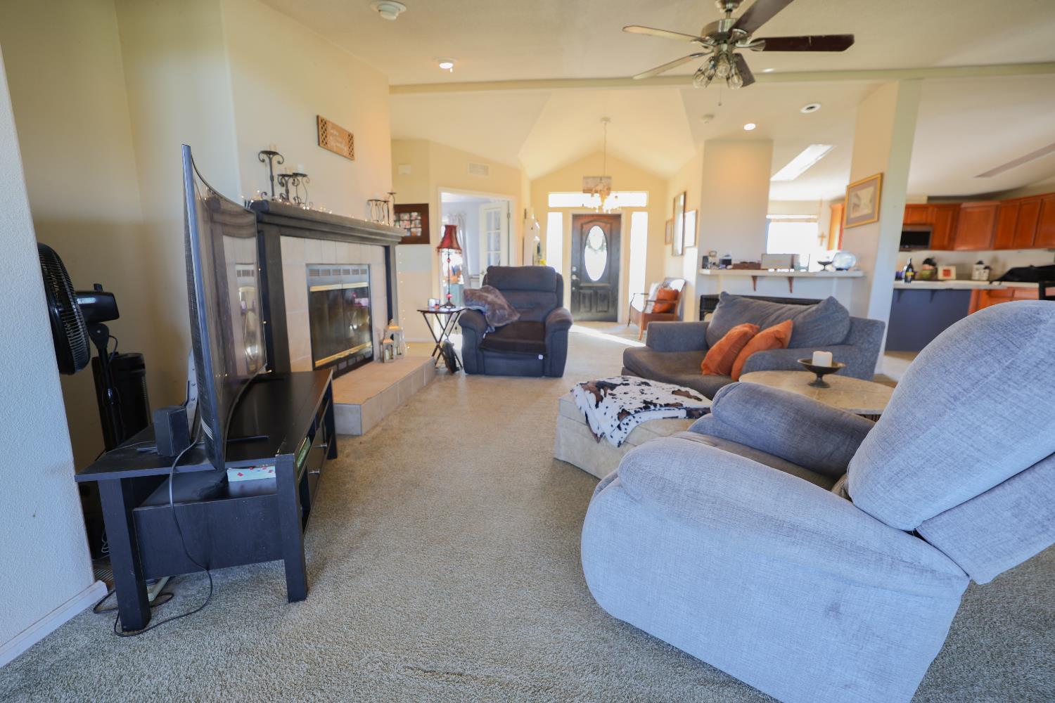 124 Wyer Road Arbuckle, CA 95912 - Photo 13 of 43 a living room with furniture a fireplace a flat screen tv and a window