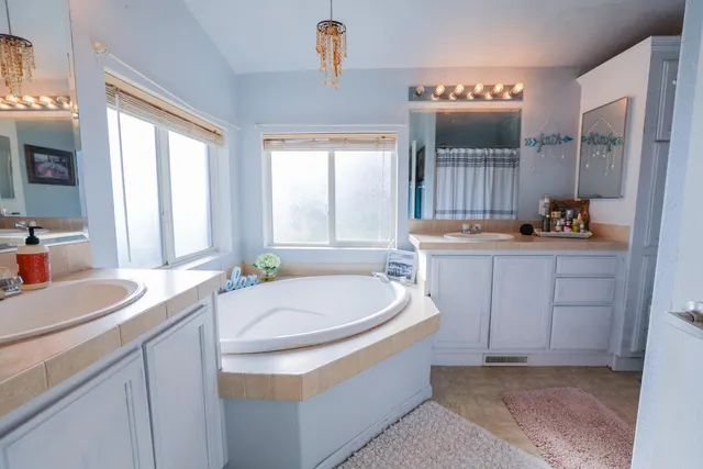 a bathroom with a granite countertop sink mirror and a bathtub