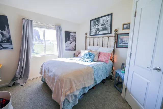 a bed sitting in a bedroom next to a window