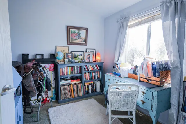 a view of a workspace with furniture and a book shelf