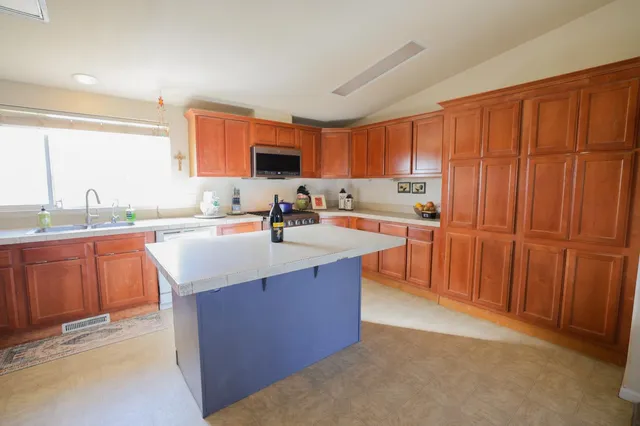 a kitchen with stainless steel appliances granite countertop a sink counter space and a window