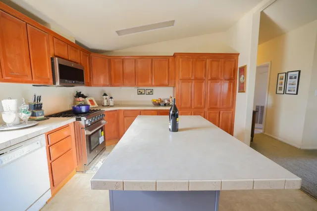 a kitchen with stainless steel appliances granite countertop a sink refrigerator and cabinets