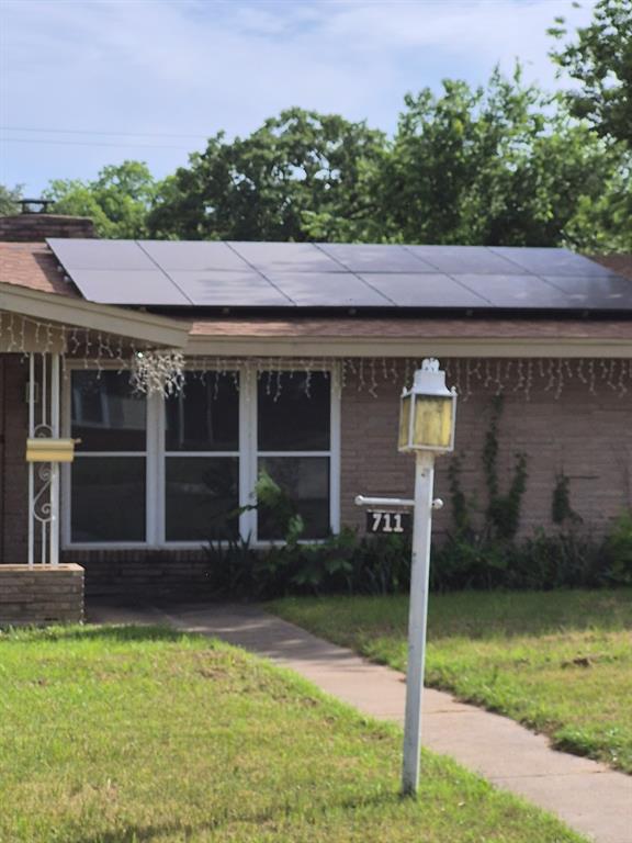 711 Cherry Street Ranger, TX 76470 - Photo 1 of 5 Brick exterior featuring a gabled roofline with solar panels