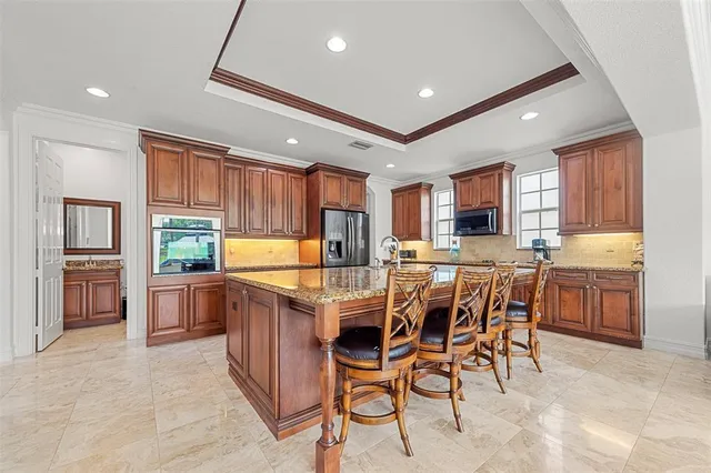 a kitchen with stainless steel appliances granite countertop a sink a stove and a refrigerator