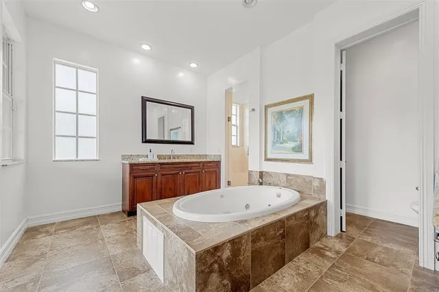 a bathroom with a tub a sink and a mirror