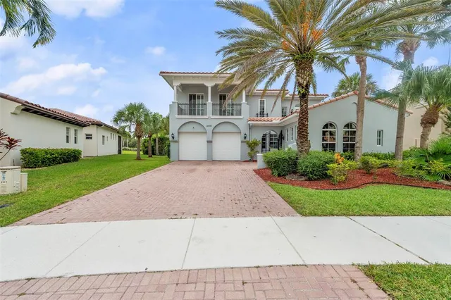 a front view of a house with a garden and trees