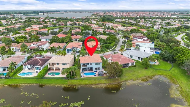 an aerial view of residential houses with outdoor space and lake view