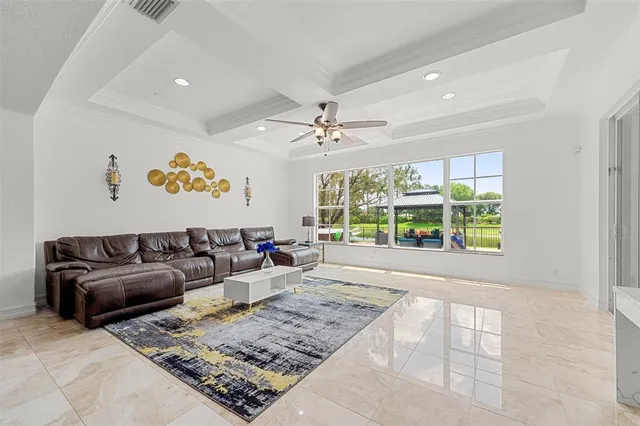 a living room with furniture kitchen view and large windows