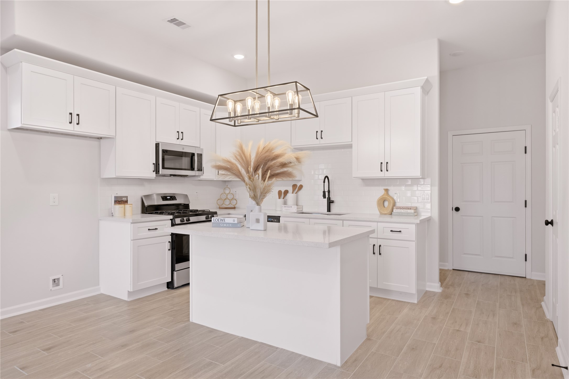 5915 Haight Street, Unit A Houston, TX 77028 - Photo 17 of 21 a kitchen with white cabinets and stainless steel appliances