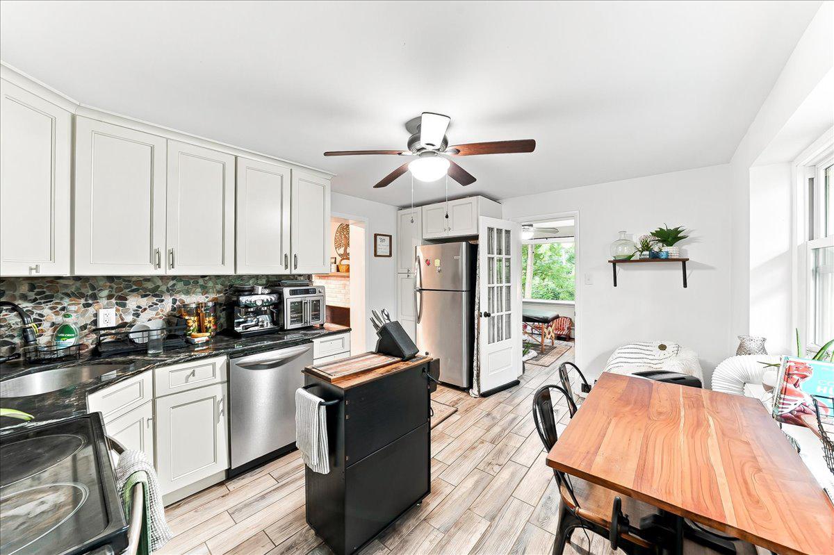 3671 St Peters Road Elverson, PA 19520 - Photo 9 of 37 a kitchen with stainless steel appliances a table chairs in it and wooden floors