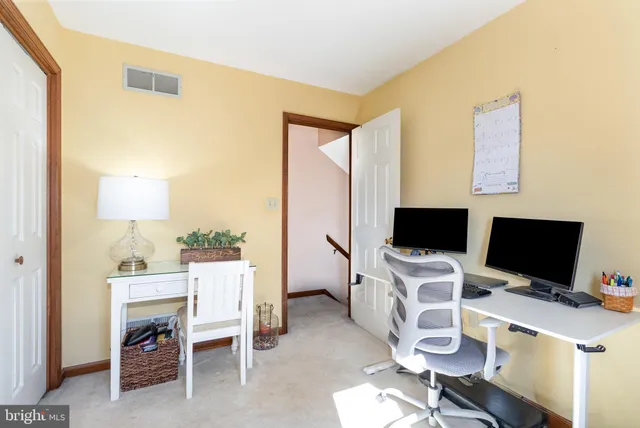 a bedroom with a bed a dresser and a chandelier