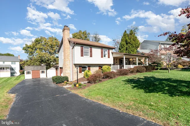a front view of a house with a yard and trees