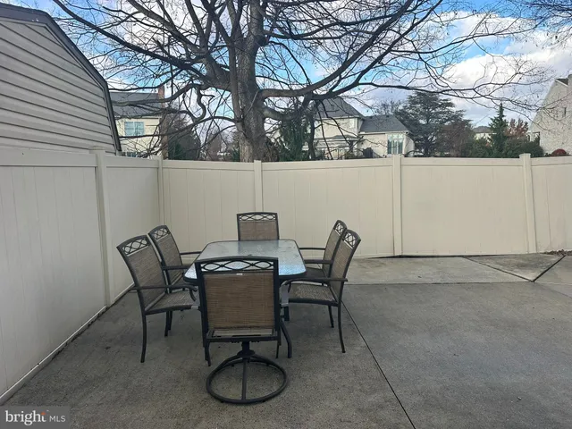 a view of a backyard with a table and chairs under an umbrella