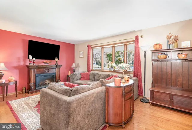 a living room with furniture a flat screen tv and a window