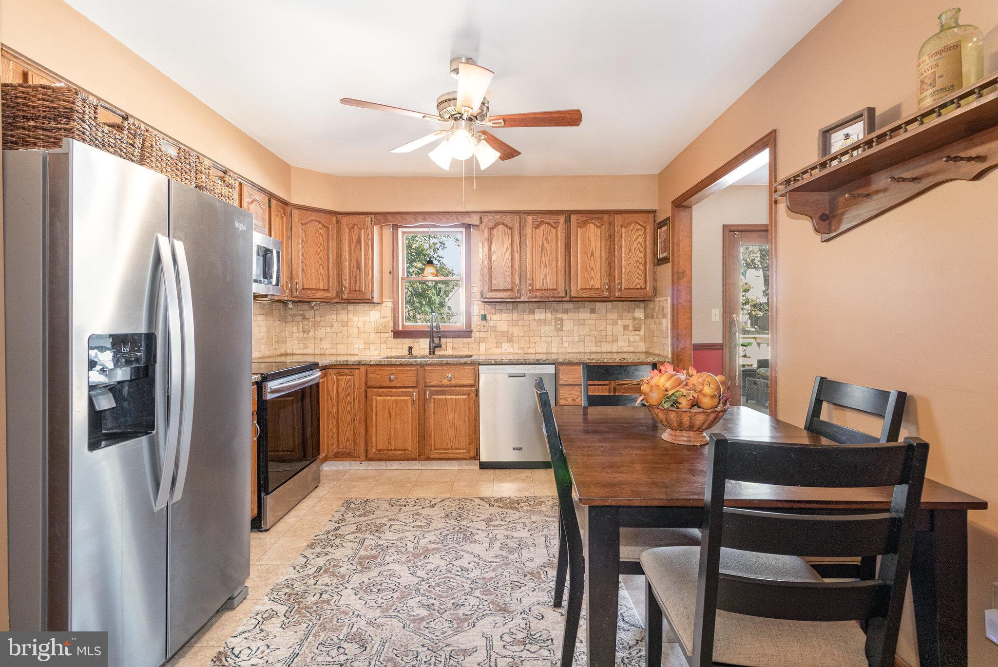 6418 Taunton Road Harrisburg, PA 17111 - Photo 9 of 39 a kitchen with refrigerator a sink and chairs
