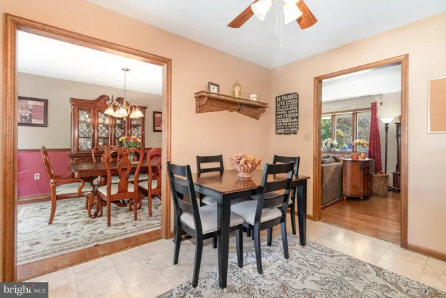 a kitchen with stainless steel appliances granite countertop a stove a refrigerator a sink a dining table and chairs