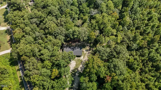 a view of a house with a lush green forest