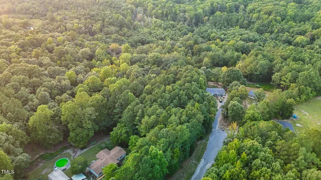 an aerial view of residential houses with outdoor space and trees