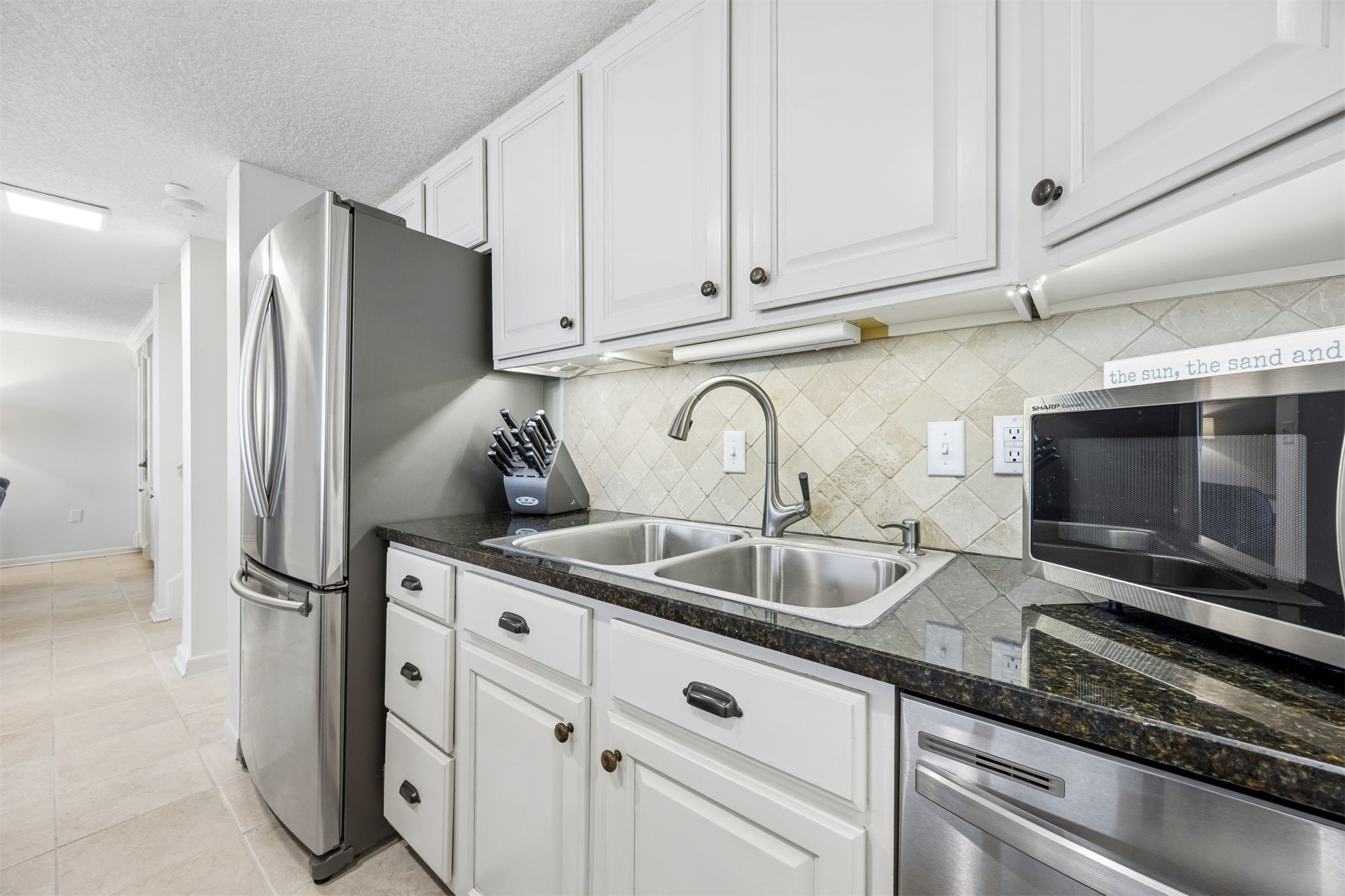 1119 Beach Walker Road, Unit 1119 Fernandina Beach, FL 32034 - Photo 18 of 32 a kitchen with stainless steel appliances granite countertop a refrigerator and a sink