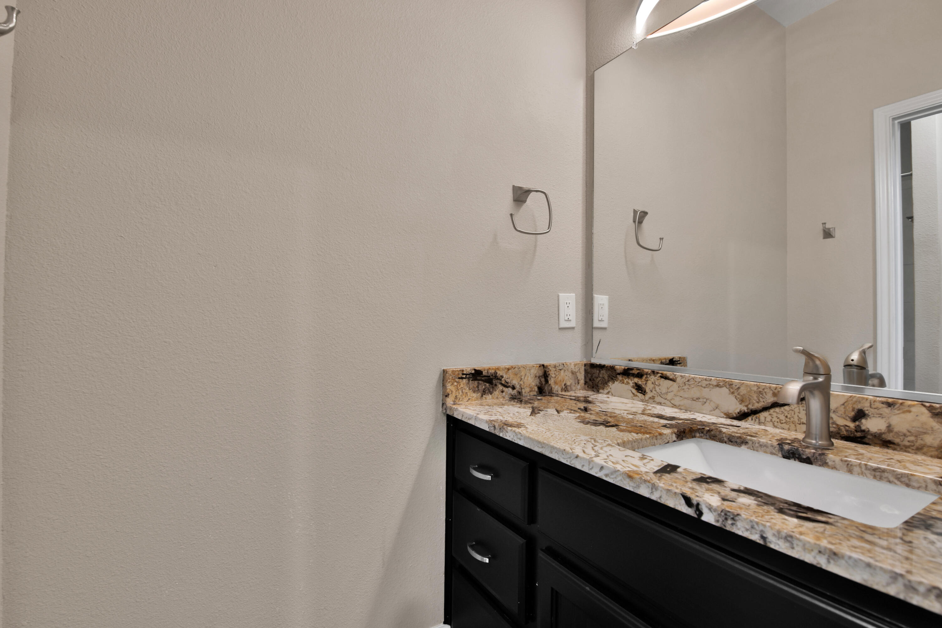 4701 109th Place Lubbock, TX 79424 - Photo 23 of 42 a bathroom with a granite countertop sink and a mirror