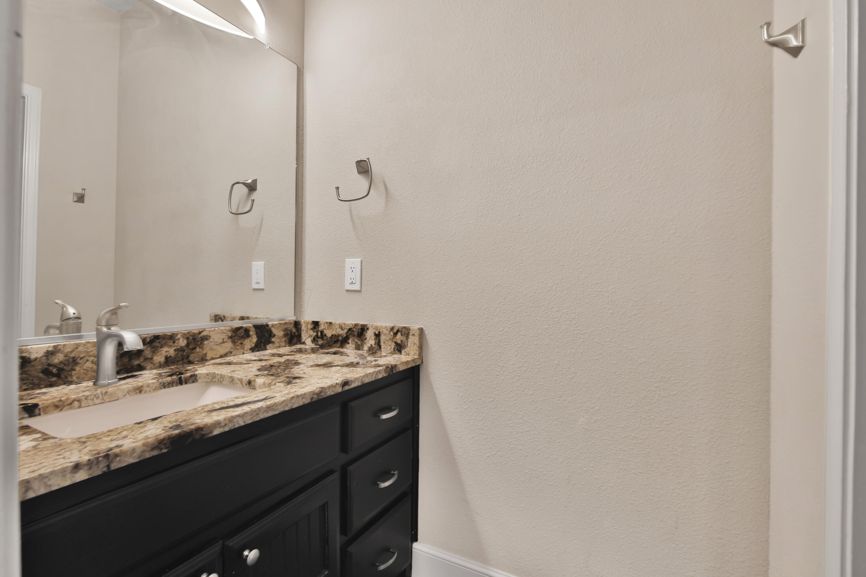 4701 109th Place Lubbock, TX 79424 - Photo 28 of 42 a bathroom with a granite countertop sink and a mirror