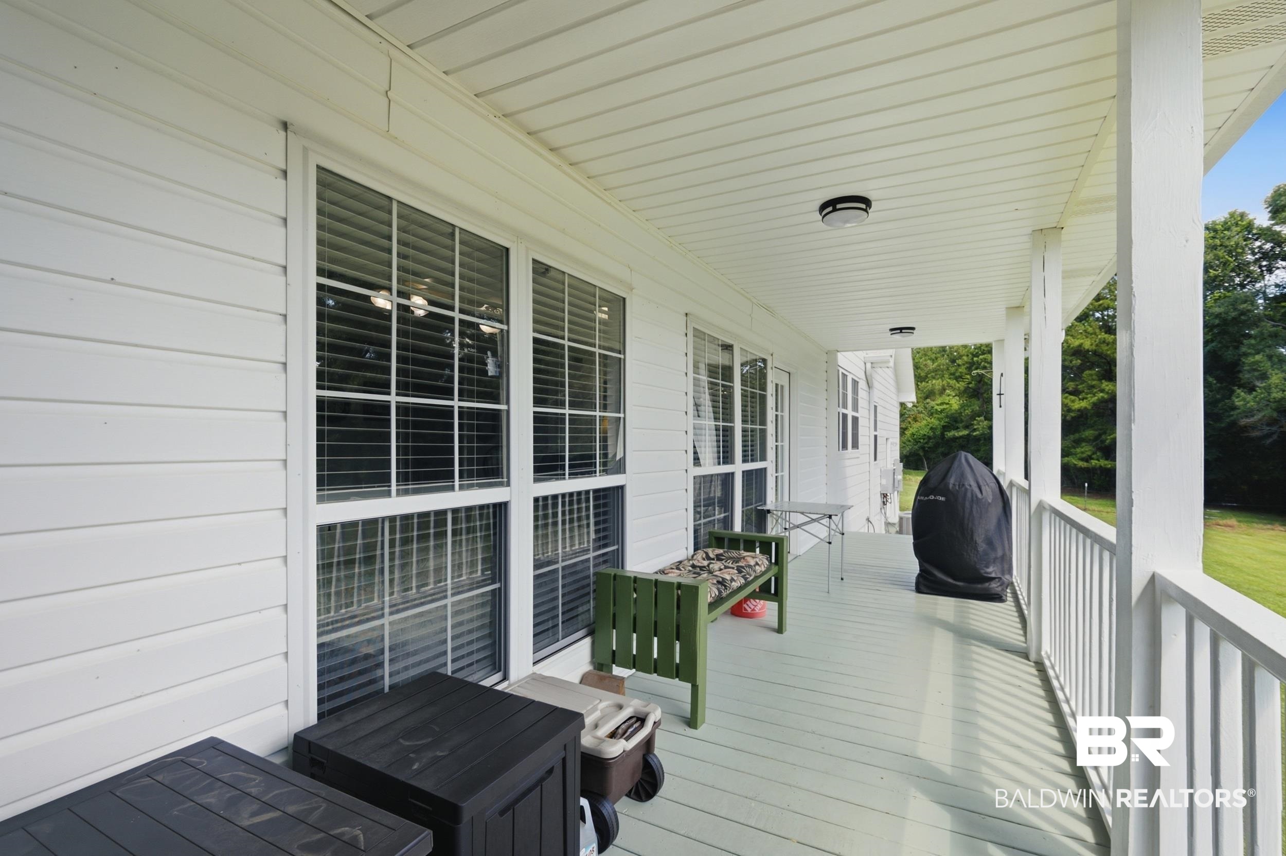 15855 Calvin Richerson Road Bay Minette, AL 36507 - Photo 18 of 83 Expansive covered porch featuring a painted floor, white railing, and exterior siding