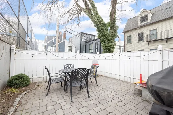 a view of a patio with table and chairs and wooden fence