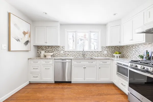 a kitchen with granite countertop white cabinets and white appliances