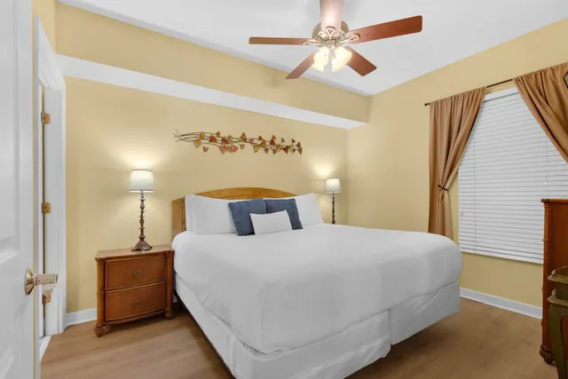 a bedroom with a bed a lamp and a ceiling fan