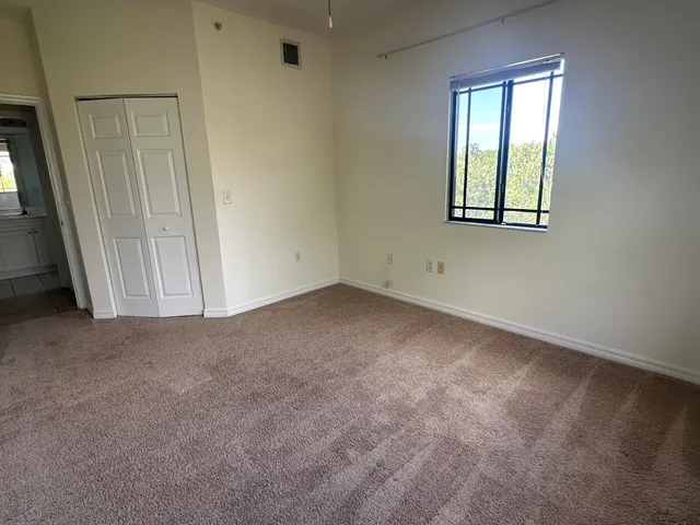 an empty room with windows and closet
