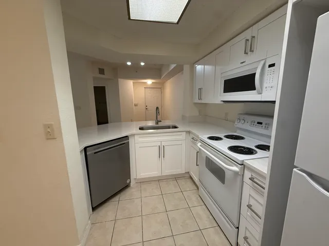 a kitchen with white cabinets stainless steel appliances and sink