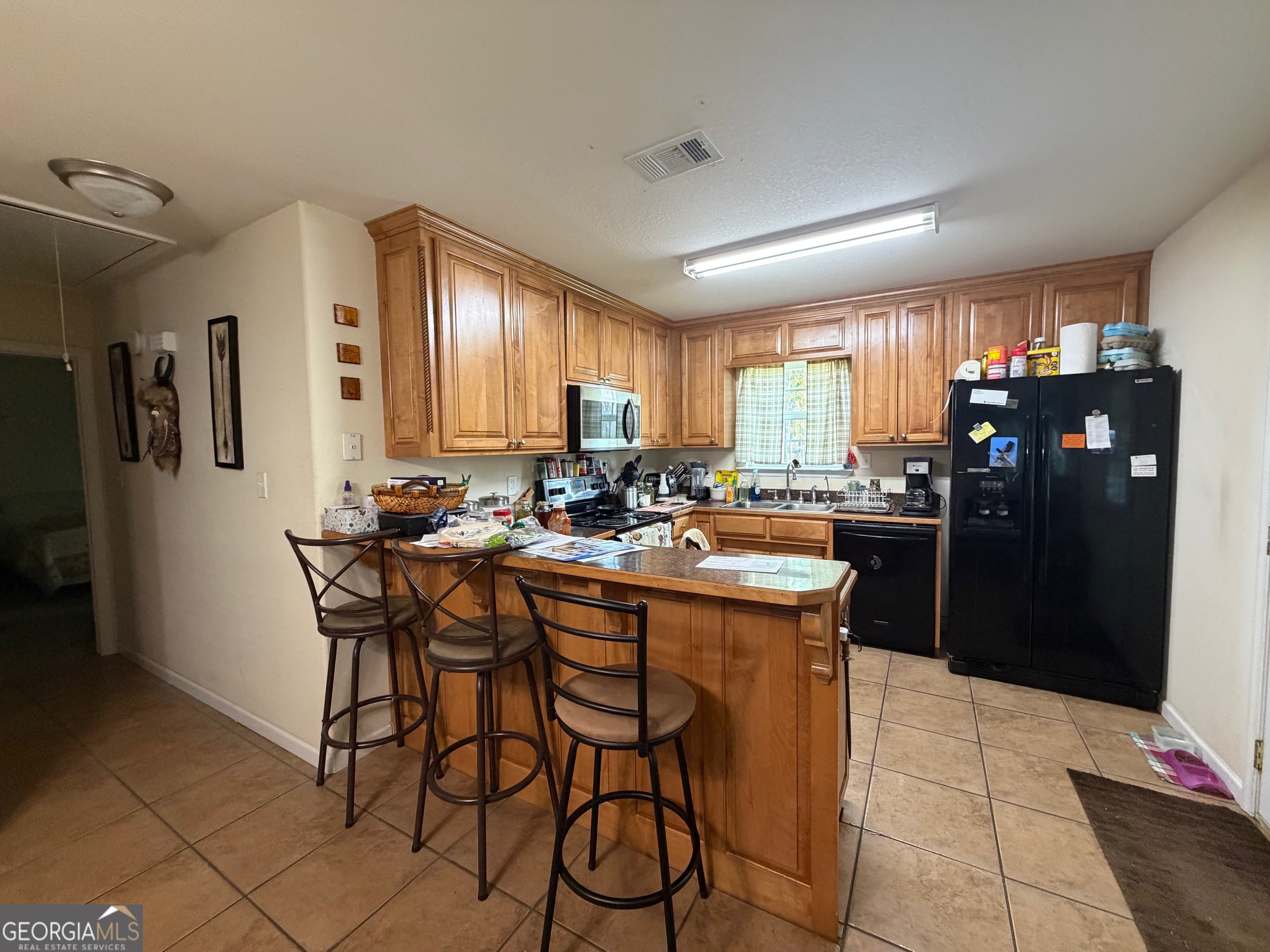 257 Mountain Laurel Road Nashville, GA 31639 - Photo 32 of 41 a kitchen with a table chairs refrigerator and cabinets