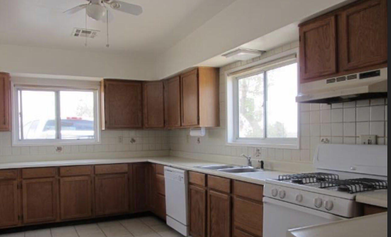 48801 97th Street East Lancaster, CA 93535 - Photo 11 of 14 a kitchen with sink window and cabinets