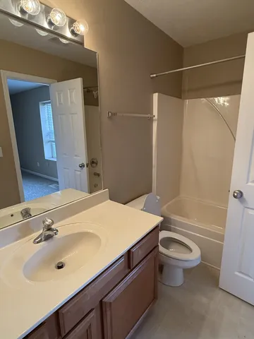 a bathroom with a sink vanity granite toilet tub and shower