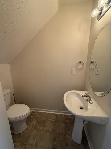 a bathroom with a sink a toilet and mirror