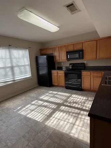 a kitchen with a stove a refrigerator and a sink