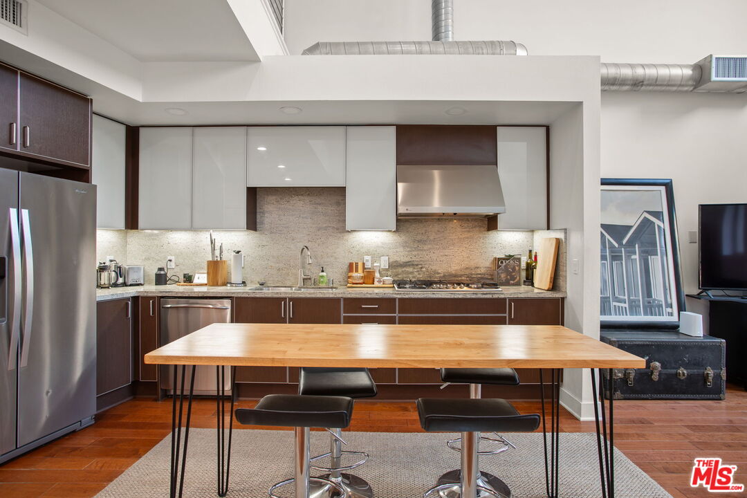 25 Delancy Irvine, CA 92612 - Photo 11 of 41 a kitchen with a table chairs refrigerator and wooden cabinets