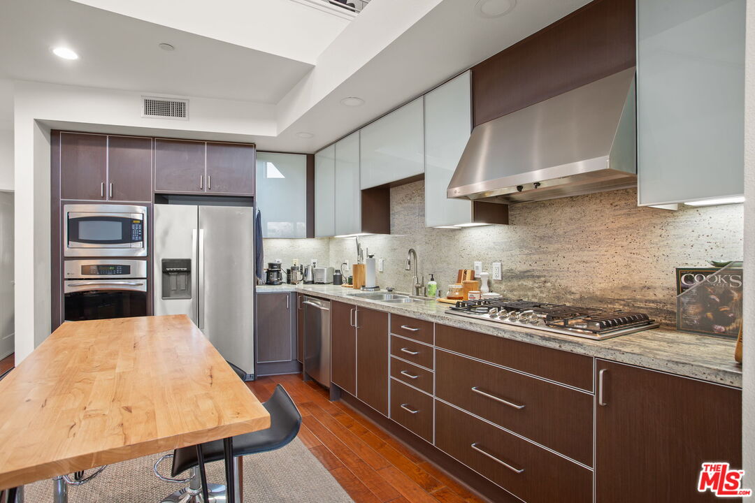25 Delancy Irvine, CA 92612 - Photo 12 of 41 a kitchen with stainless steel appliances granite countertop a sink stove and refrigerator