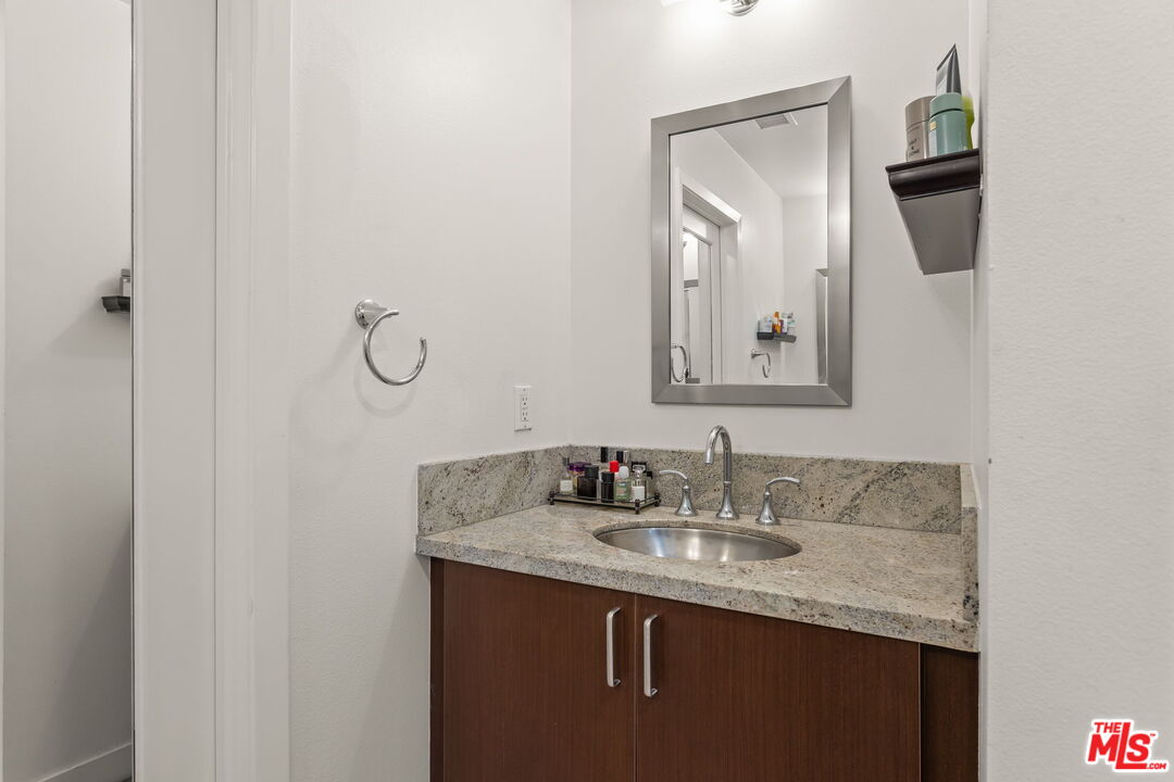 25 Delancy Irvine, CA 92612 - Photo 19 of 41 a bathroom with a granite countertop sink a mirror and vanity