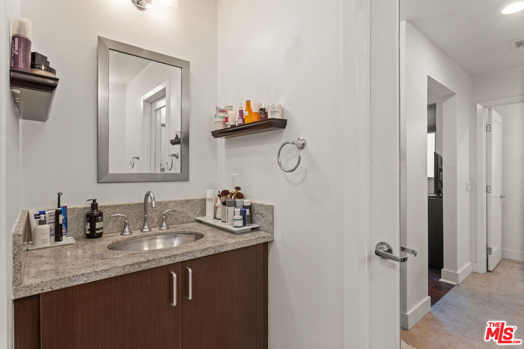 25 Delancy Irvine, CA 92612 - Photo 20 of 41 a bathroom with a granite countertop sink and a mirror