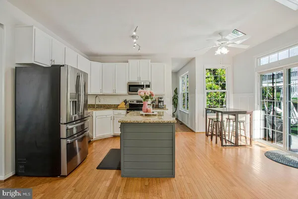 a kitchen with a refrigerator cabinets and wooden floor