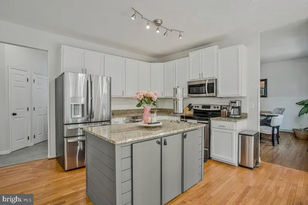 a kitchen with a sink a microwave a refrigerator and cabinets