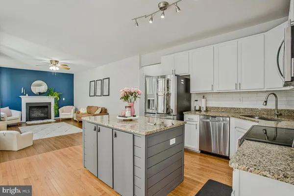 a kitchen with stainless steel appliances granite countertop a stove top oven a sink dishwasher and a refrigerator